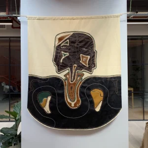 Textile art featuring stylized head and neck anatomy with abstract design elements