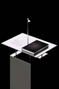 Isometric illustration of desk with book, papers, and reading lamp on pedestal